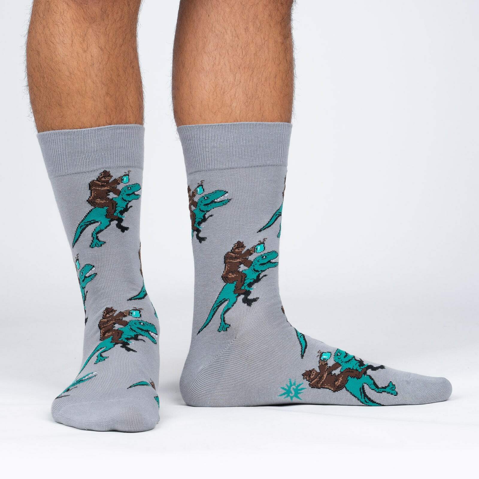 model side view of Cup of Ambition - Sasquatch Dinosaur Coffee Crew Socks - Men's
